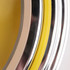 A close-up of a double ring wall clock with yellow, silver, and chrome accents. The design features a glossy finish.