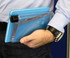 A drink bottle in a sleek, transparent design with a blue back, held alongside a notepad. Features a logo.