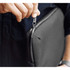 A person holding a black laptop caddy, highlighting the zip closure detail. The caddy has a sleek design and branding.