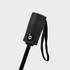 A compact umbrella handle in black with a strap and button detail. Features a sleek design.