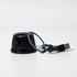 A compact black speaker with a blue accent ring and a USB cable. It features a sleek, modern design.