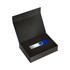 A blue and silver USB drive sits inside a black magnetic gift box lined with foam. The box is open.