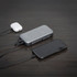 A Bluetooth speaker powerbank in silver and black, connecting to a smartphone and wireless earbuds.