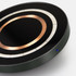 A wireless charger in black and green, featuring a copper circle design and a small blue indicator light.