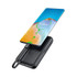 A black wireless power bank with a smartphone above, indicating a charging status. The design is sleek and modern.
