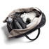 A black and beige duffel bag containing a water bottle, shoes, and a grey pouch. The bag has a logo.