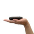 A slim black wireless travel mouse rests in an outstretched hand, showcasing its compact design.