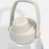 A drink bottle in clear plastic with a light grey lid and handle, featuring a logo on the lid.