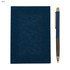 A blue notebook with a textured cover and a matching pen with a gold accent, featuring a logo.
