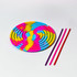 A sensory activity board in rainbow colours, featuring a swirl design and three coloured straws beside it.