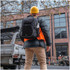 A black High Sierra Access 4.0 backpack rests on the back of a person wearing a hard hat and bright orange vest.