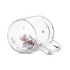 A clear glass Christmas-themed double wall mug with decorative confetti inside. It features a handle and a logo.