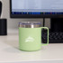 A drink bottle in pastel green with a stainless steel rim and handle, featuring a logo.