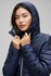 A unisex navy soft shell jacket with a hood, featuring a quilted design and a model holding it closed.