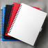 A collection of spiral-bound journals in blue, black, red, and white, each featuring a branded logo.