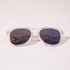 Clear frame sunglasses with dark lenses, featuring a sleek design and subtle branding.