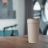 A drink bottle made from wheat straw in a neutral beige colour, featuring a lid and a simplistic design.