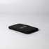 A black pocket mirror with a sleek, minimalist design, featuring a logo on its surface.