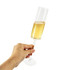 A hand holding a clear straight champagne flute filled with bubbly golden liquid. The glass features a smooth stem and base.