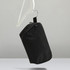 A black toiletry bag with a hanging hook, featuring a simple design and a logo.