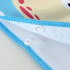 A hooded change towel featuring a colourful design with a blue border and snap buttons for secure closure.