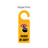 A custom shape acrylic door hanger in bright yellow, featuring a design of lips and a finger shushing.