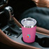 A drink bottle in a car’s centre console, featuring a pink stainless steel double wall design and a lid.