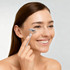 A stainless steel facial roller held by a smiling woman with long brown hair, featuring a sleek silver design.