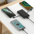 A black 5000mAh slim power bank with charging cables, connected to two smartphones on a table.