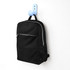 A black urban sports backpack with a front zip pocket and mesh side pocket, hanging on a blue hook.