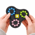 A hands holding a black puzzle game featuring blue, green, pink, and yellow components with a logo in the centre.