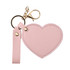 A pink heart-shaped compact mirror with a gold keychain attachment. Includes a strap for easy carrying.
