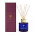 A reed diffuser with a blue glass bottle, gold lid, and bamboo reeds, packaged in a purple box.