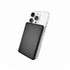 A black solid-state power bank is positioned against a silver smartphone, highlighting its sleek design and portable size.