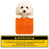 An orange 4-section lick mat with various textures held by a fluffy dog, featuring a warning label at the bottom.