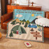 A tapestry blanket featuring a camping scene with mountains, trees, a tent, and a caravan in green and blue hues.