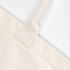 A close-up of a cream-coloured tote bag with textured handles and no gusset, featuring a logo.