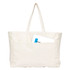A large cream canvas tote bag with two handles and a front pocket, featuring an item partially tucked inside.