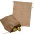 A jute bag in a natural brown colour with a drawstring, containing several green potatoes.