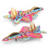 A vibrant pink and blue wooden model of a jet fighter with a colourful design and a logo on it.