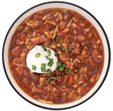 Bowl of ReadyWise High Plateau veggie chili soup topped with sour cream and green onions
