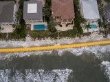 Guppy MAX Heavy-Duty Water-Filled Flood Barrier protecting a row of beachfront homes