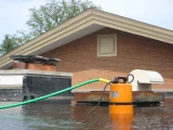 Sea Sponge Flood Water Pump draining a flooded rooftop through a garden hose