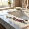 A lifestyle photo of the gum 509 toothbrush lying on a marble sink in a sunny bathroom