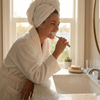 A lifestyle photo of a woman in a bathroom in a bathrobe brushing her teeth with the gum 509 toothbrush