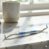 generate a lifestyle photo of the sulcus brush lying on a marble sink in a sunny bathroom