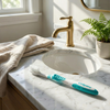 Colgate Wave Ultra-Compact Head Soft Toothbrush, Soft Bristles for Gentle Plaque Removal, Compact Curved Head for Hard-to-Reach Area. View of toothbrush lying on a marble sink