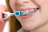 Edel+White ProOrtho UltraSoft Orthodontic Toothbrush with Anti-Stress Handle Closeup view with person brushing