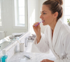 DentalPro Size 6 -Extra  Large I-Shape purple Interdental Brushes 10-Pack view of a woman cleaning her teeth in a bathroom