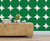 Rustic side table with lamp candles and books on top in front of green circles wallpaper